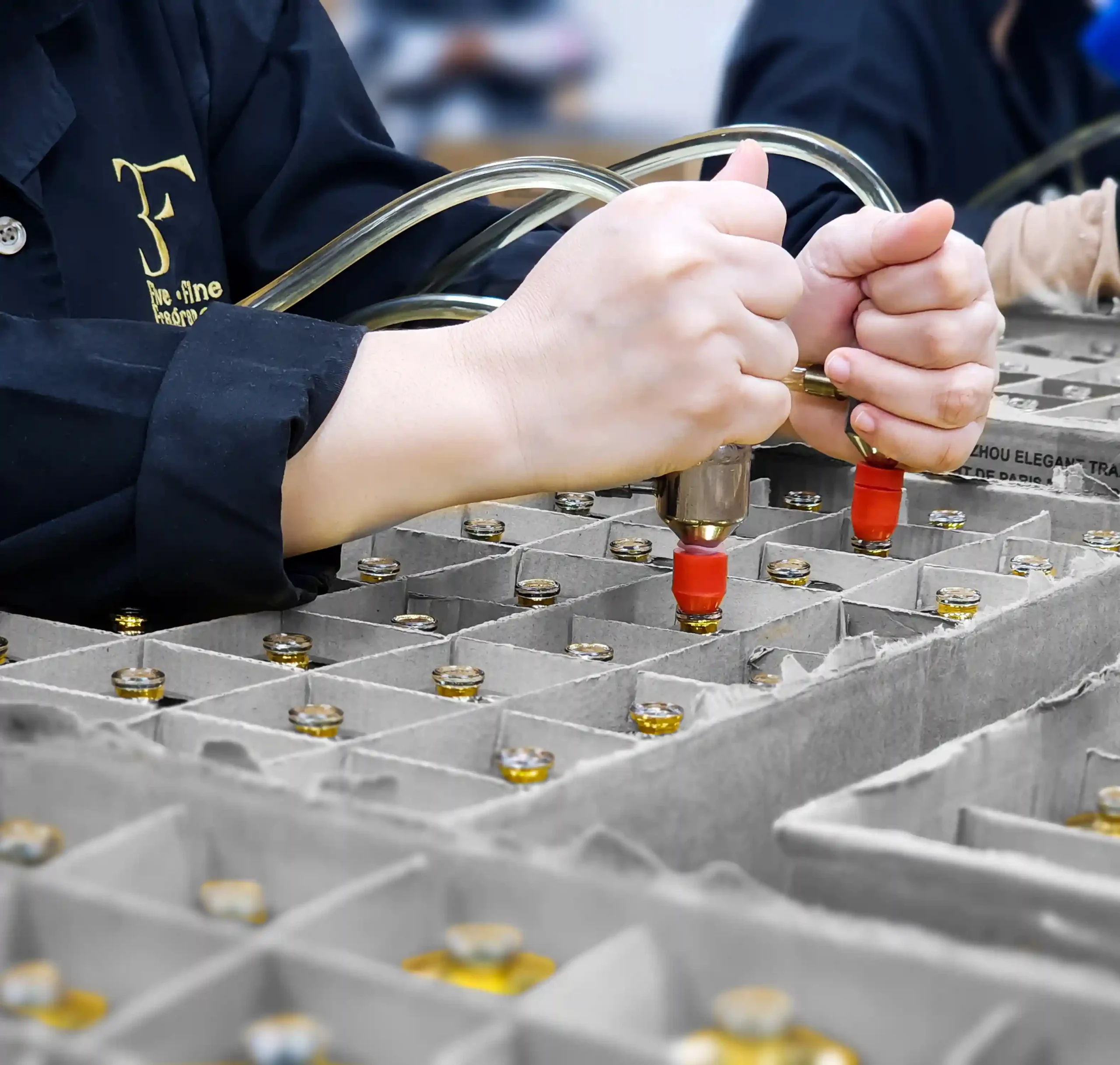 Premium Perfume Manufacturers in UAE 1 3F Perfumes employee filling perfume bottles in our manufacturing facility, demonstrating quality craftsmanship and production expertise.