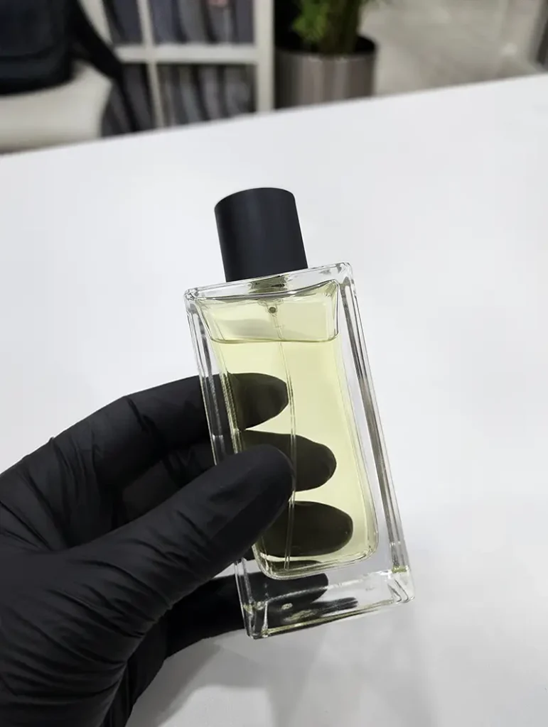 Our Commitments | 3F Perfumes Private Label Expertise 3 Hands holding plain glass perfume bottles filled with fragrances, representing fully customizable private label perfume options at 3F Perfumes UAE.